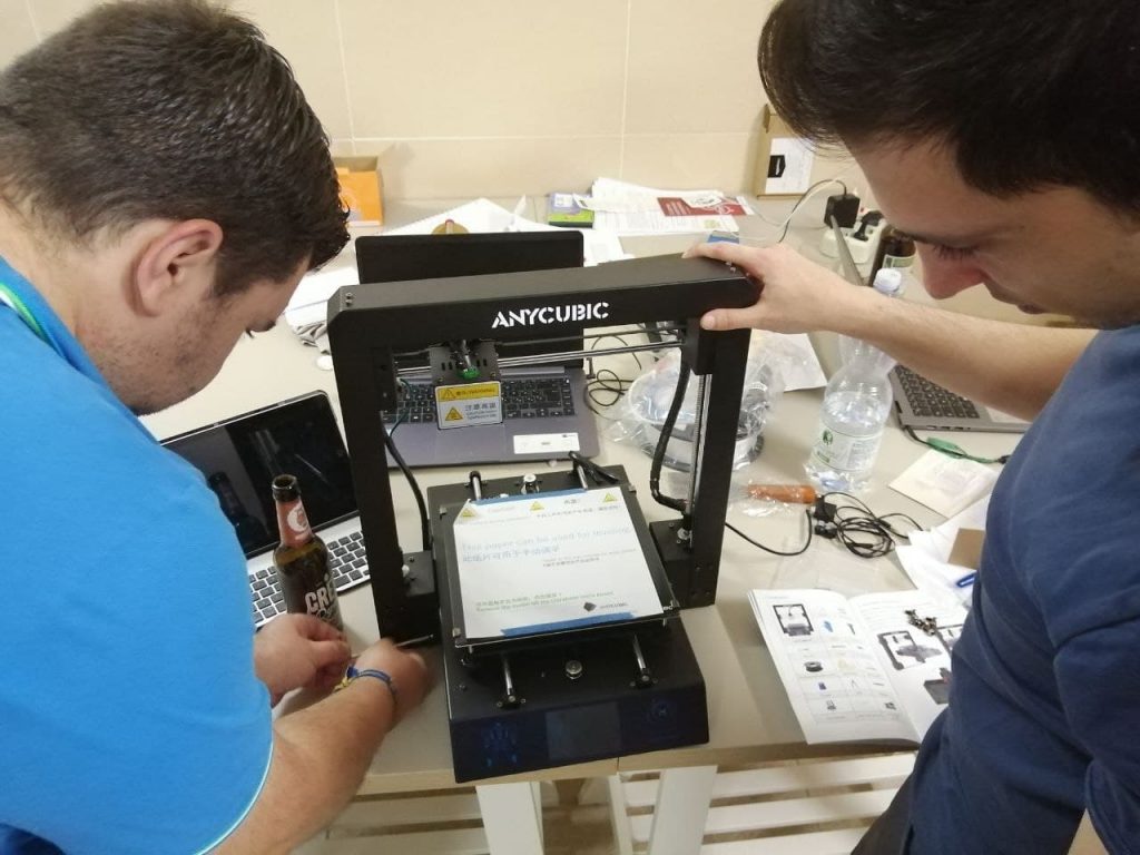 giovani che lavorano con stampante 3D per la prototipazione di materiale